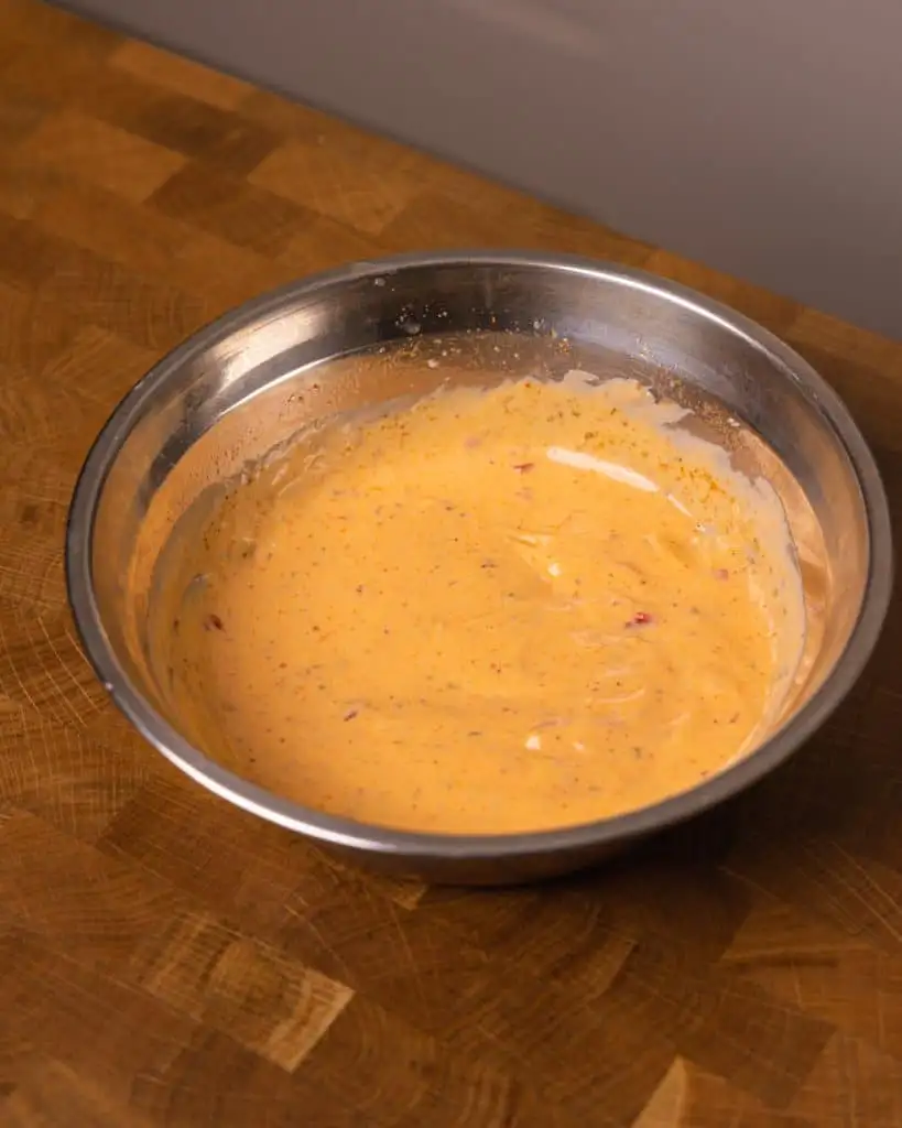 Creamy spicy sauce mixture in a stainless steel bowl. - GENIUS EATS Bang Bang Salmon sauce