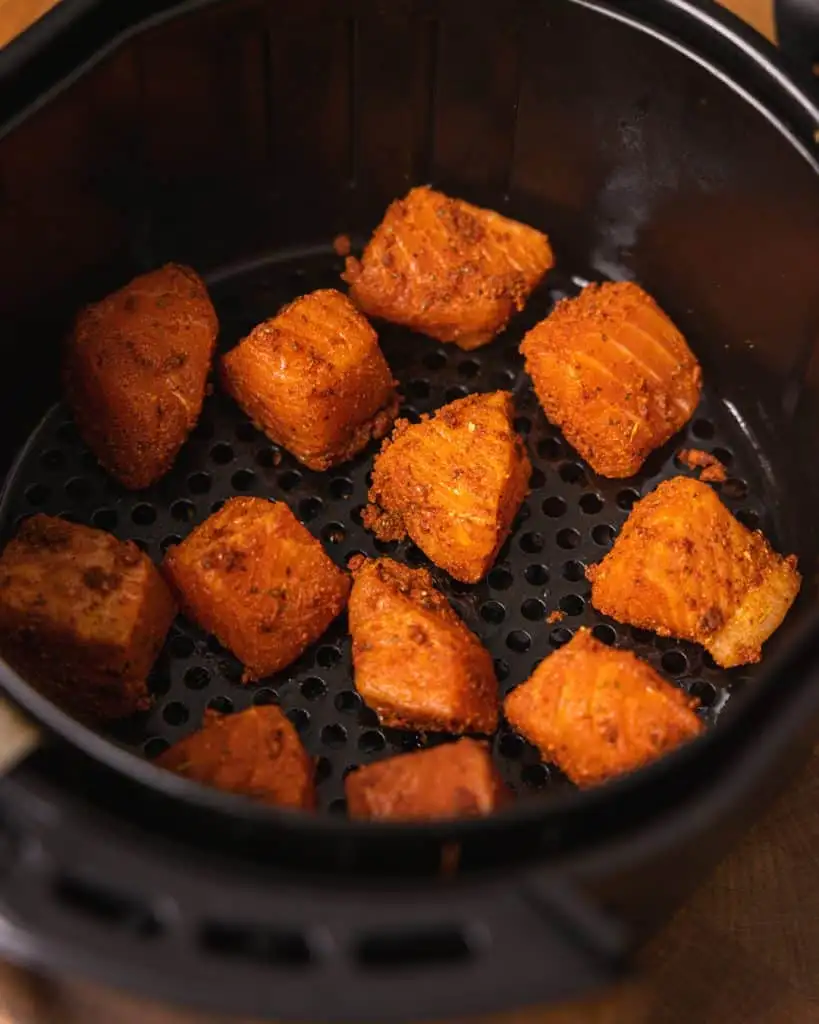 Air fryer bang bang salmon bites - GENIUS EATS Salmon in the air fryer basket.