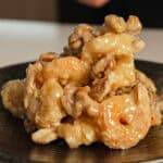 Creamy honey walnut shrimp piled on a plate.