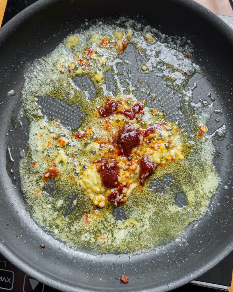 Garlic sautéing in melted butter with added kimchi