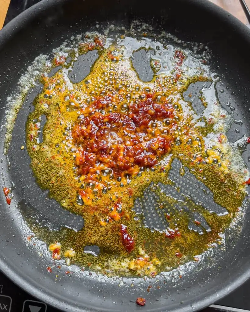 Kimchi cooking in a pan with butter and garlic - GENIUS EATS Kimchi cooking in a pan with butter and garlic