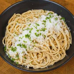 Creamy garlic butter spaghetti topped with grated Parmesan and fresh chives.