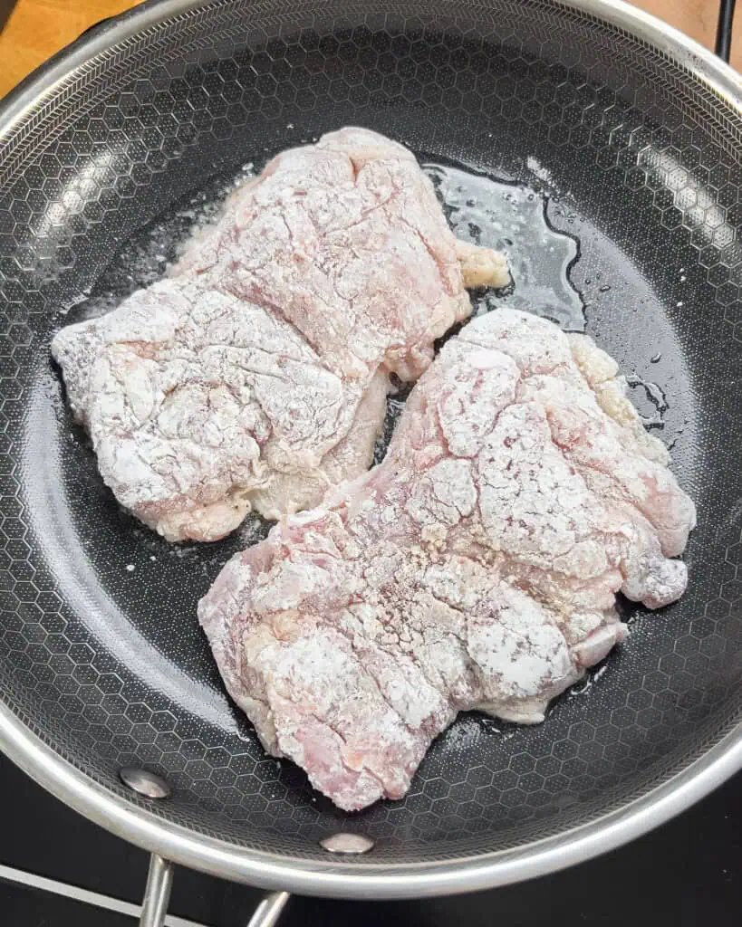 Dredged chicken thighs placed skin-side down in a hot skillet - GENIUS EATS Dredged chicken thighs placed skin-side down in a hot skillet
