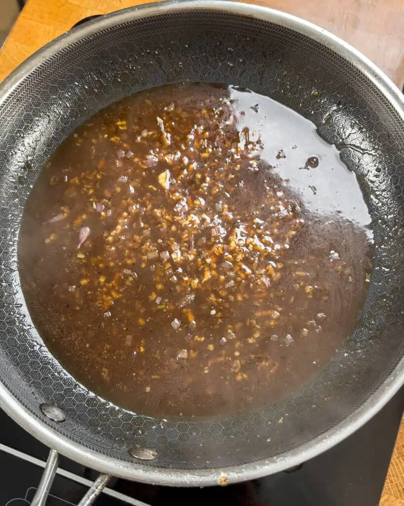 Glossy black pepper sauce bubbling and thickening in the skillet - GENIUS EATS Glossy black pepper sauce bubbling and thickening in the skillet