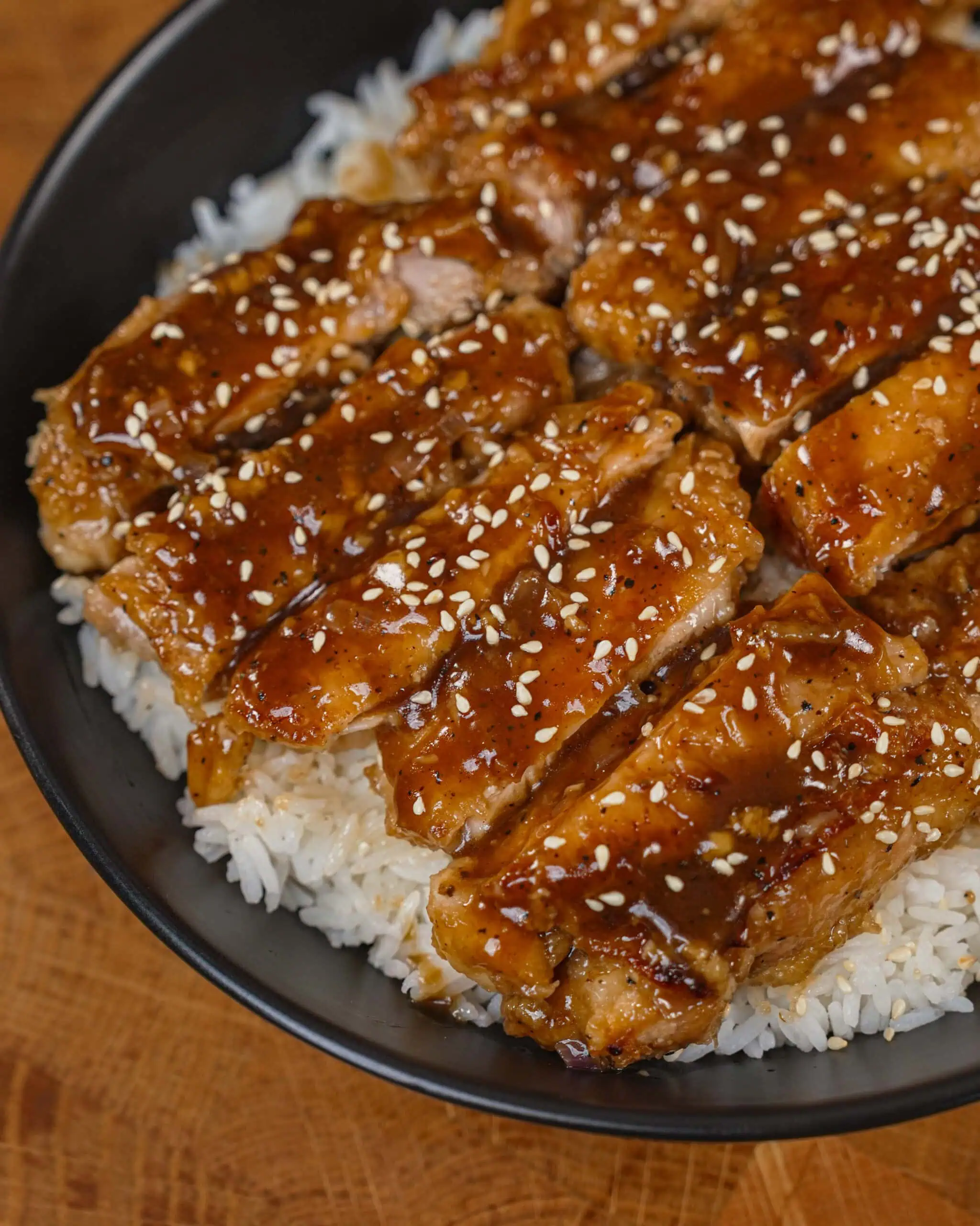 Glazed sesame chicken slices served over steamed rice in a bowl. - GENIUS EATS Homemade black pepper chicken wings