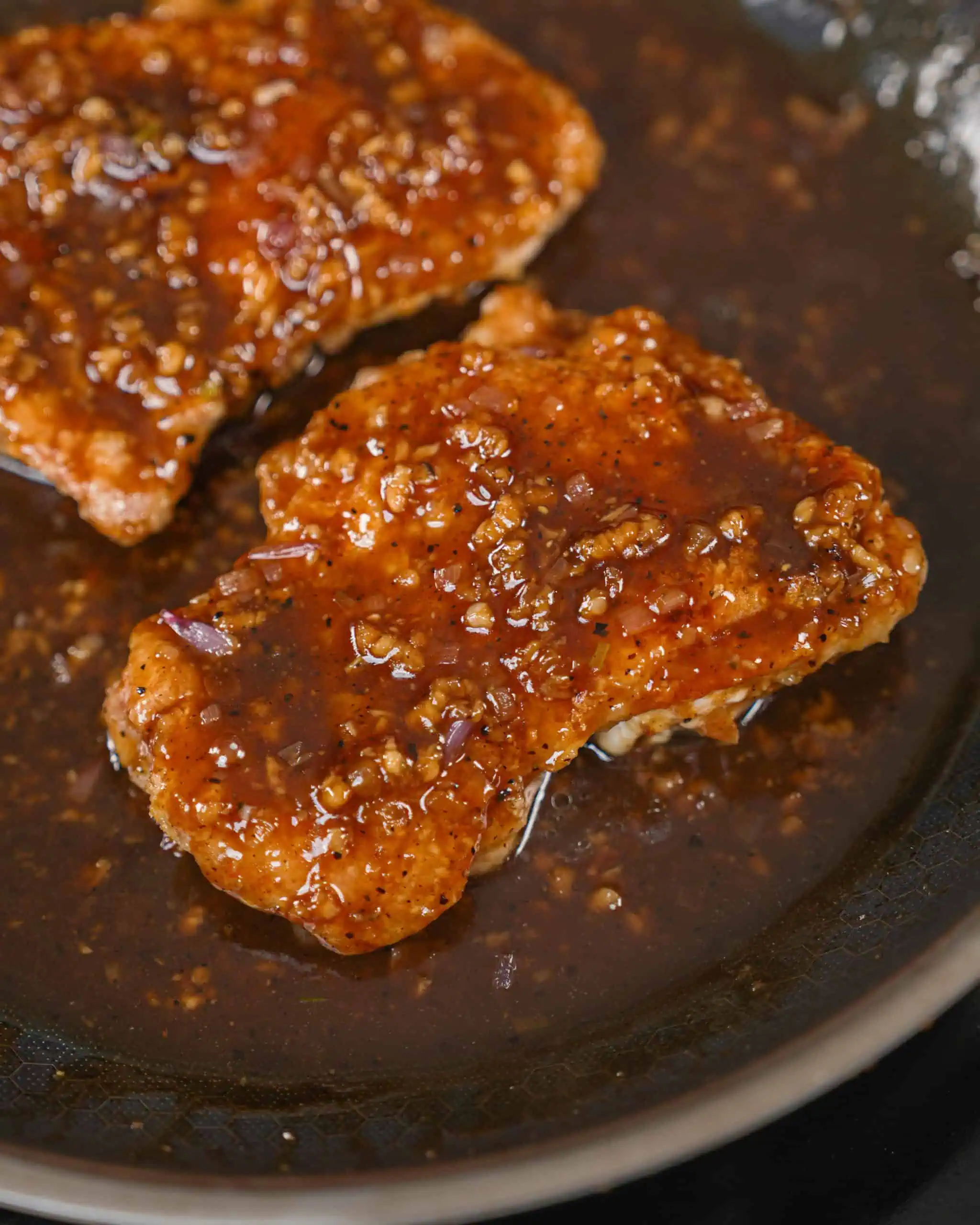 Crispy chicken cutlets coated in a sticky garlic sauce in a skillet. - GENIUS EATS Spicy black pepper chicken recipe