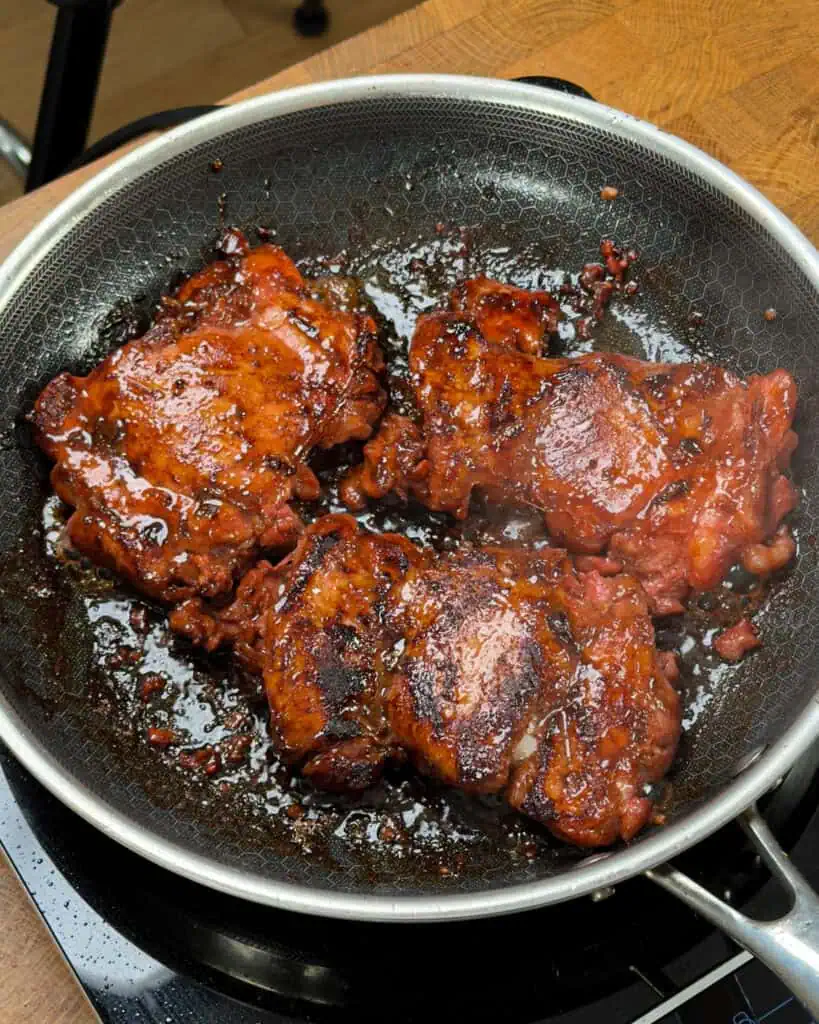 Chicken caramelizing in a non-stick pan developing a glossy brown surface - GENIUS EATS Chicken caramelizing in a non-stick pan developing a glossy brown surface