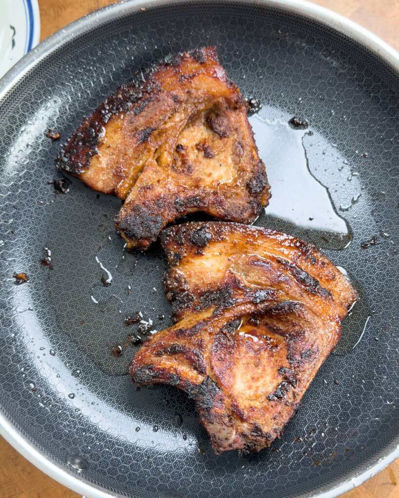 Golden brown pork chops cooking in skillet Vietnamese style