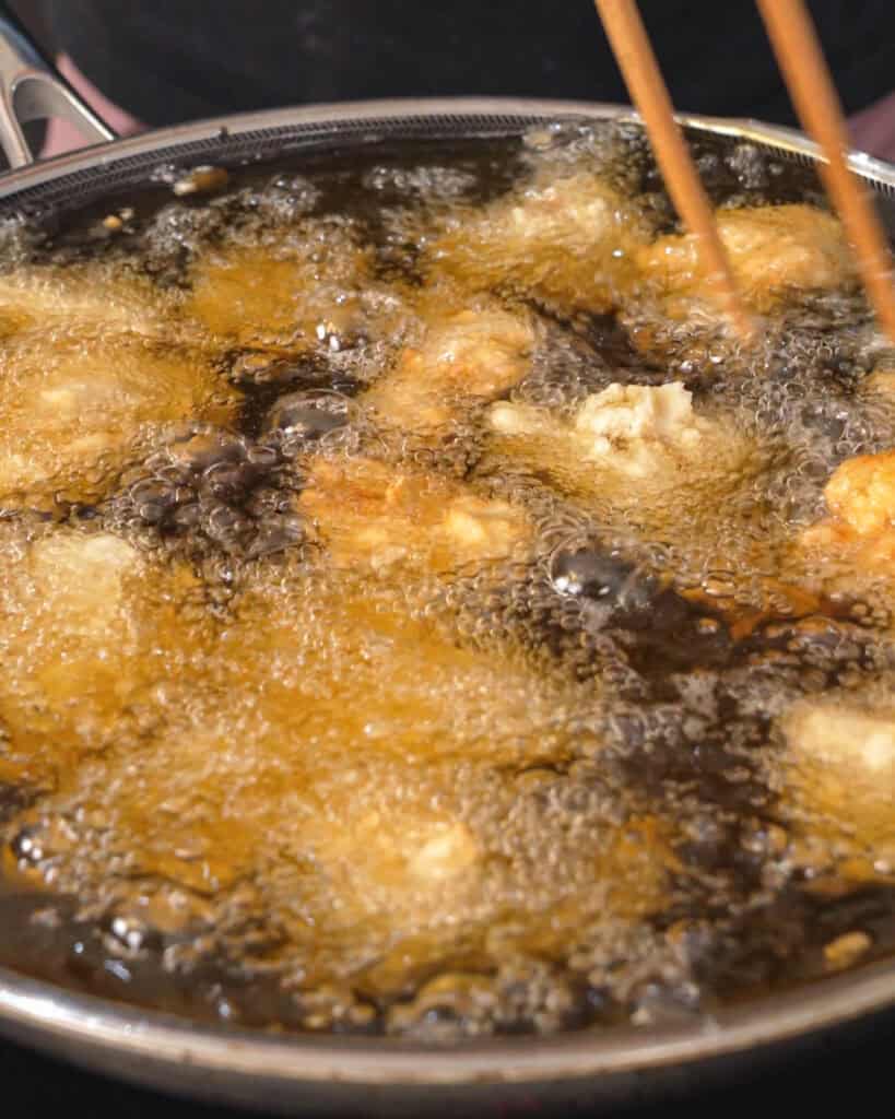 Pressing potato starch onto marinated chicken for karaage - GENIUS EATS Pressing potato starch onto marinated chicken for karaage