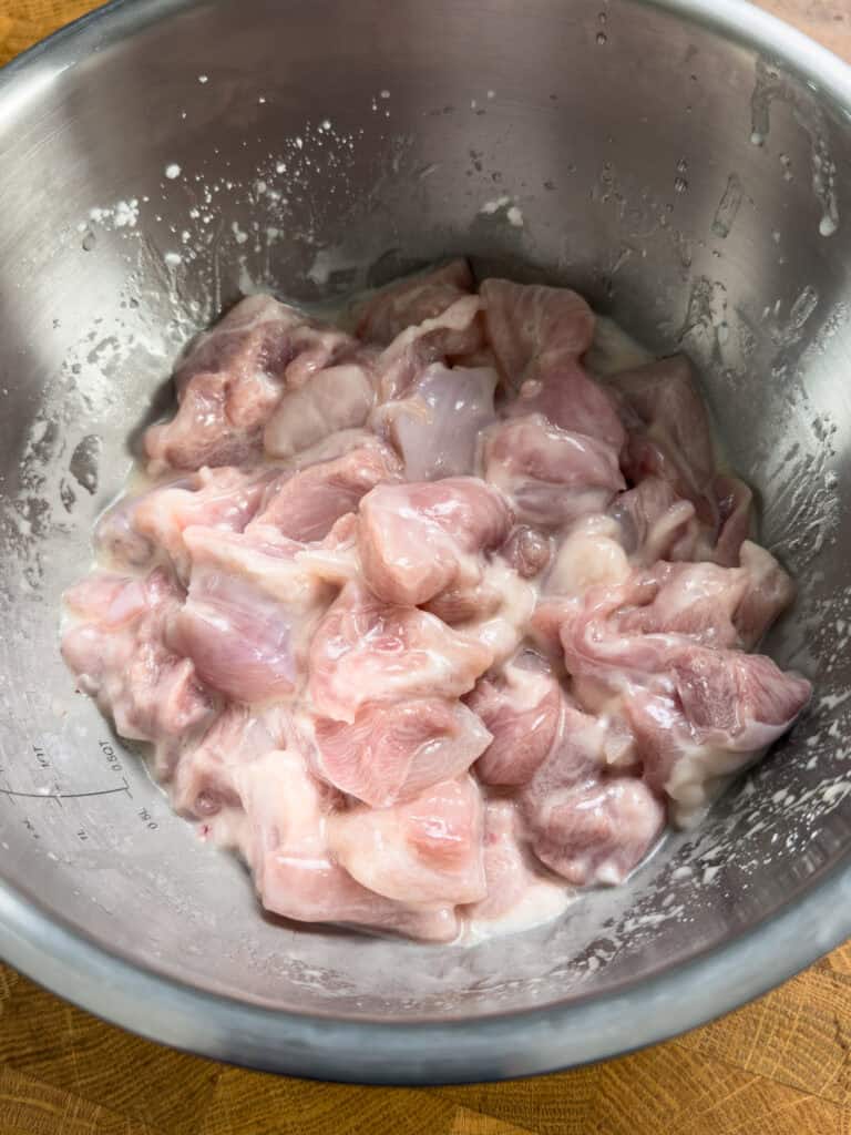 Chicken pieces coated evenly in wet marinade before cooking Kung Pao Chicken