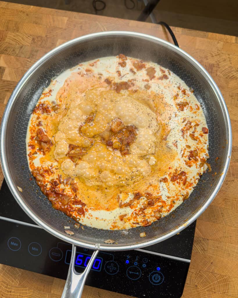 Dark red paste added to kimchi bacon mixture