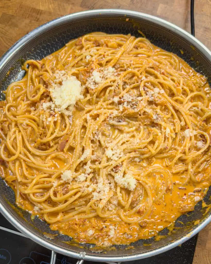 Grated Parmesan scattered over Kimchi Bacon Pasta in pan - GENIUS EATS Grated Parmesan scattered over Kimchi Bacon Pasta in pan