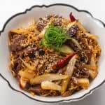 Delicious beef stir-fry with vegetables, noodles, and sesame seeds, perfect for a quick and flavorfu.