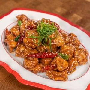 Delicious sweet and spicy chicken with sesame seeds and green onions. Perfect for a flavorful Asian-.