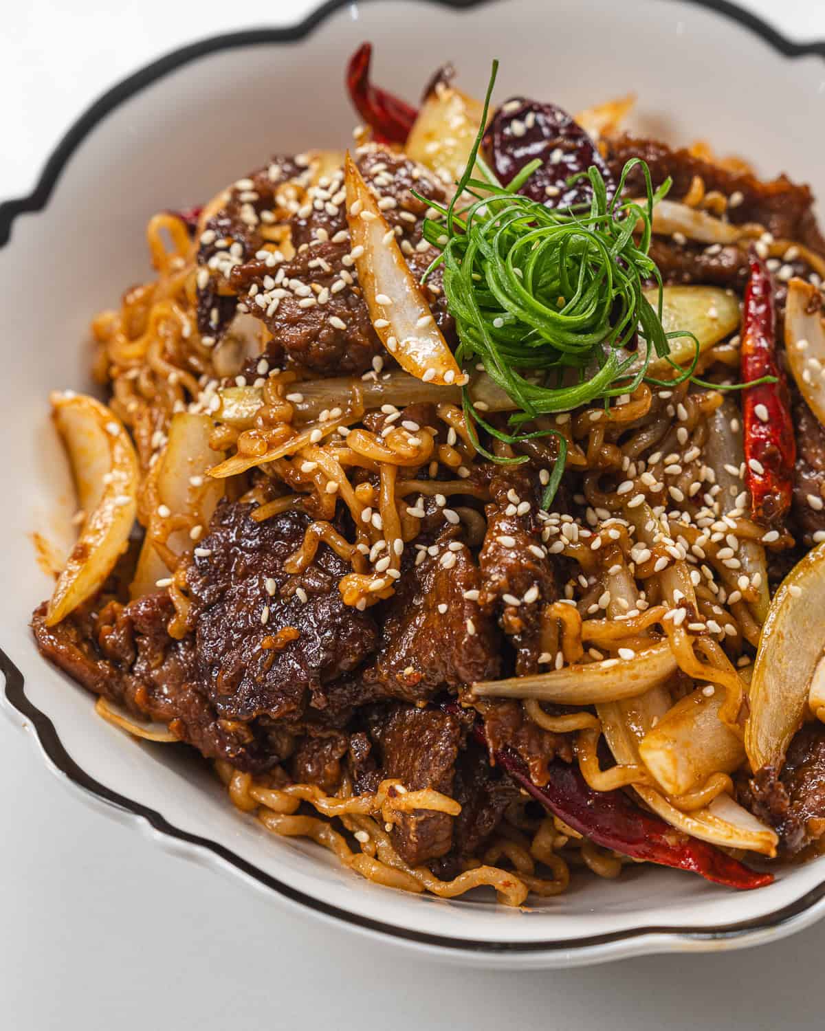 Delicious beef stir-fry with vegetables, noodles, and sesame seeds, perfect for a quick and flavorfu.