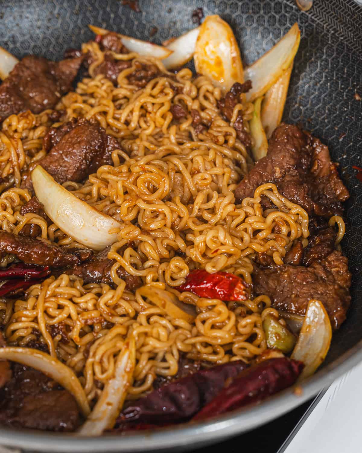 Fried noodles with tender beef, onions, and peppers, perfect for a quick and flavorful meal.