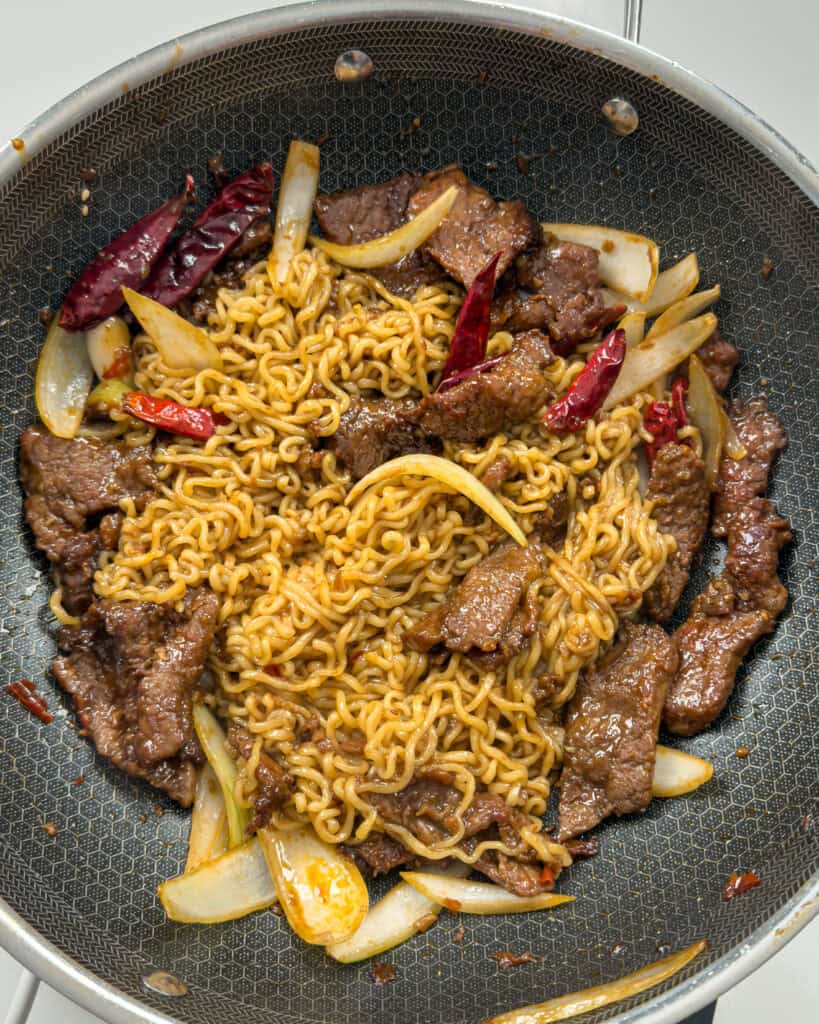 Noodles and beef combined in pan for Mongolian Beef Noodles