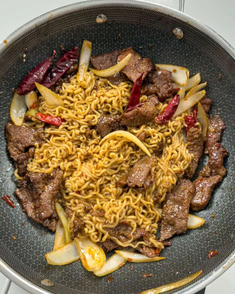 Noodles and beef combined in pan for Mongolian Beef Noodles - GENIUS EATS Noodles and beef combined in pan for Mongolian Beef Noodles
