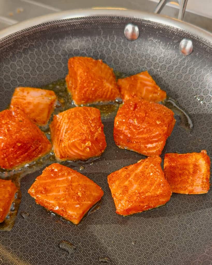 Salmon cubes arranged in an oiled pan