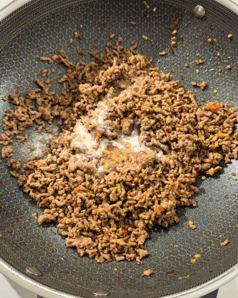 Seasoning added to cooked minced pork in pan - GENIUS EATS Seasoning added to cooked minced pork in pan