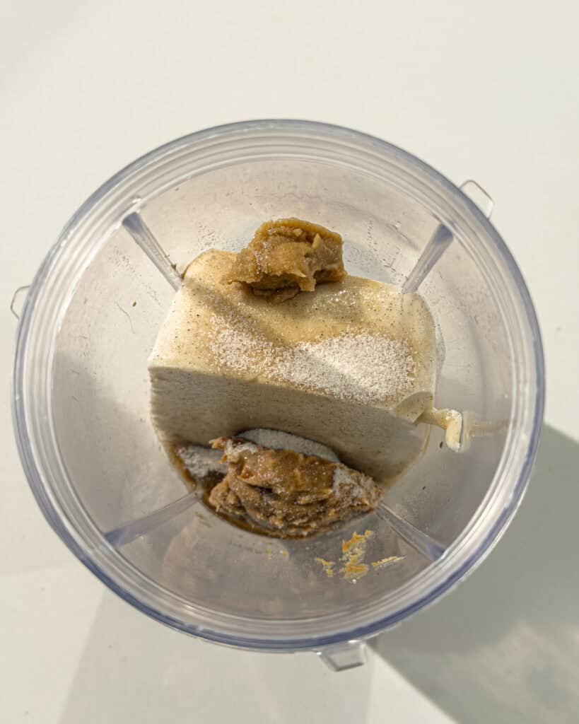 Silken tofu and thick pastes placed inside a blender cup