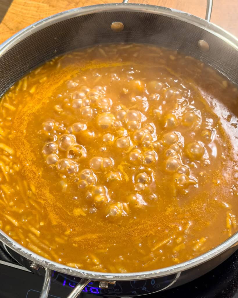 Delicious homemade caramel sauce simmering in a pan. Perfect for desserts and sweet treats.