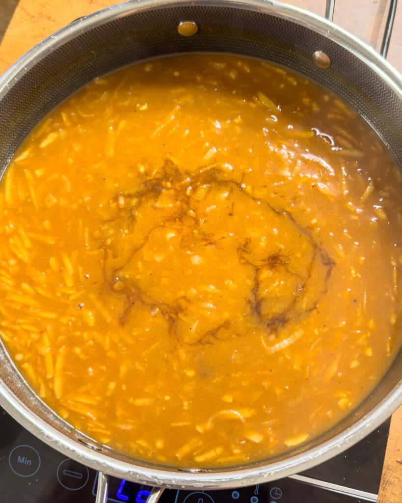 Immersion blender blending curry sauce until smooth