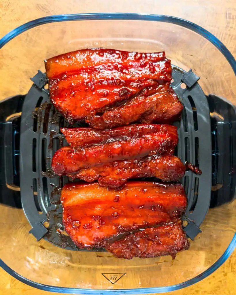 Pork belly strips arranged on air fryer rack - GENIUS EATS Pork belly strips arranged on air fryer rack