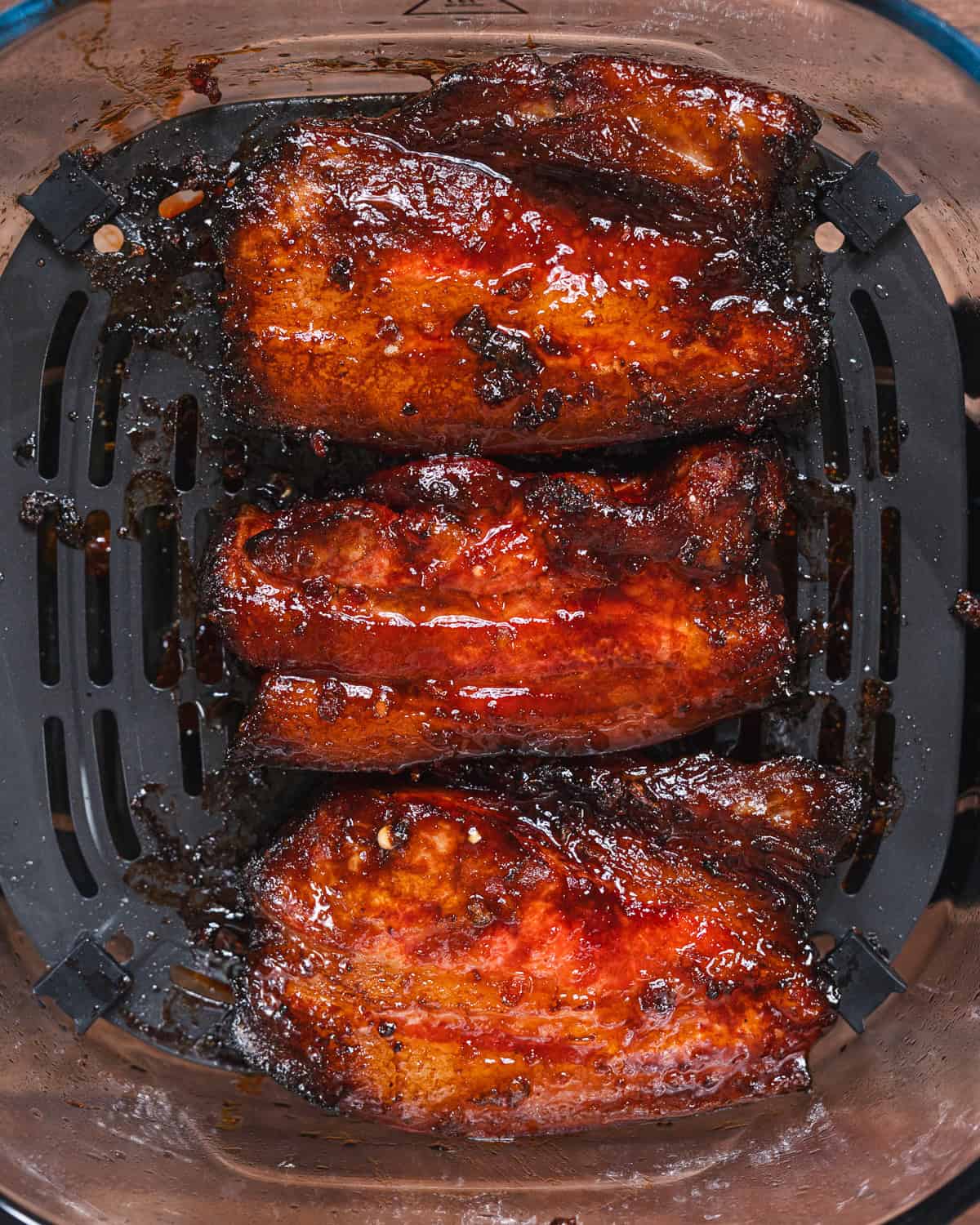 Delicious glazed BBQ ribs cooked in an air fryer, showcasing crispy edges and tender meat. Perfect f.