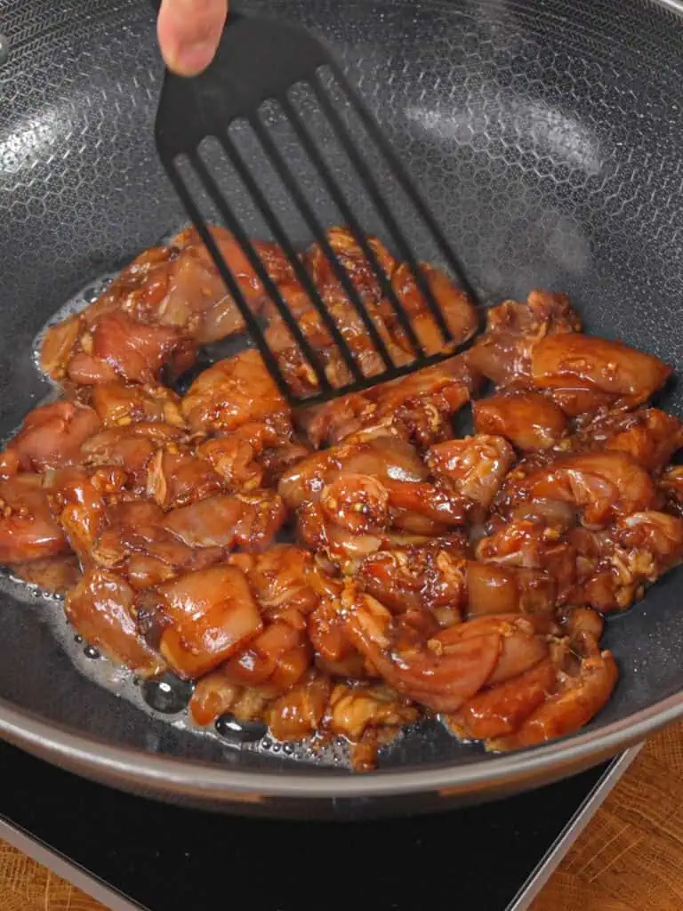 Marinated chicken stir-frying in a wok for General Tso-Style Chicken Chow Mein. - GENIUS EATS Marinated chicken stir-frying in a wok for General Tso-Style Chicken Chow Mein.