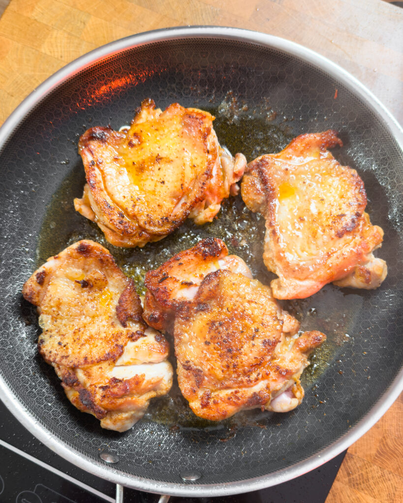 Browning chicken pieces in a pan for Creamy Gochujang Coconut Chicken - GENIUS EATS Browning chicken pieces in a pan for Creamy Gochujang Coconut Chicken