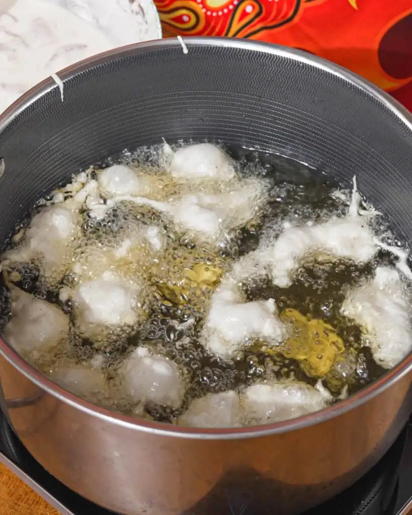 Coated chicken pieces frying in bubbling oil for Honey Chicken - GENIUS EATS Coated chicken pieces frying in bubbling oil for Honey Chicken