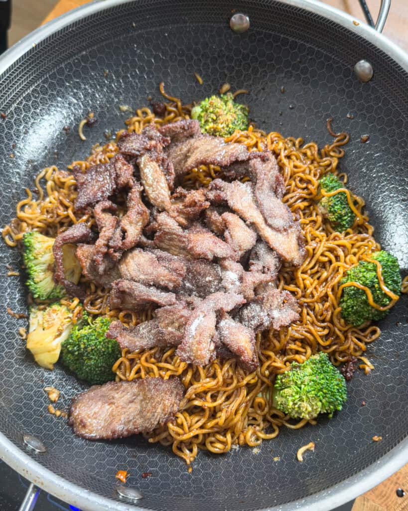 Cooked beef strips added over noodles and broccoli - GENIUS EATS Cooked beef strips added over noodles and broccoli