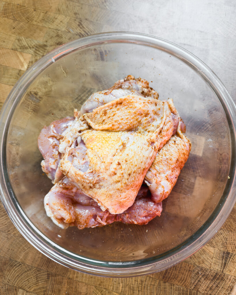 Raw seasoned chicken in a glass bowl - GENIUS EATS Raw seasoned chicken in a glass bowl