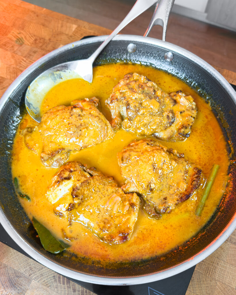 Yellow-orange sauce with chicken and visible green aromatics - GENIUS EATS Yellow-orange sauce with chicken and visible green aromatics
