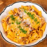 Gochujang chicken alfredo pasta plated and garnished with parsley and parmesan