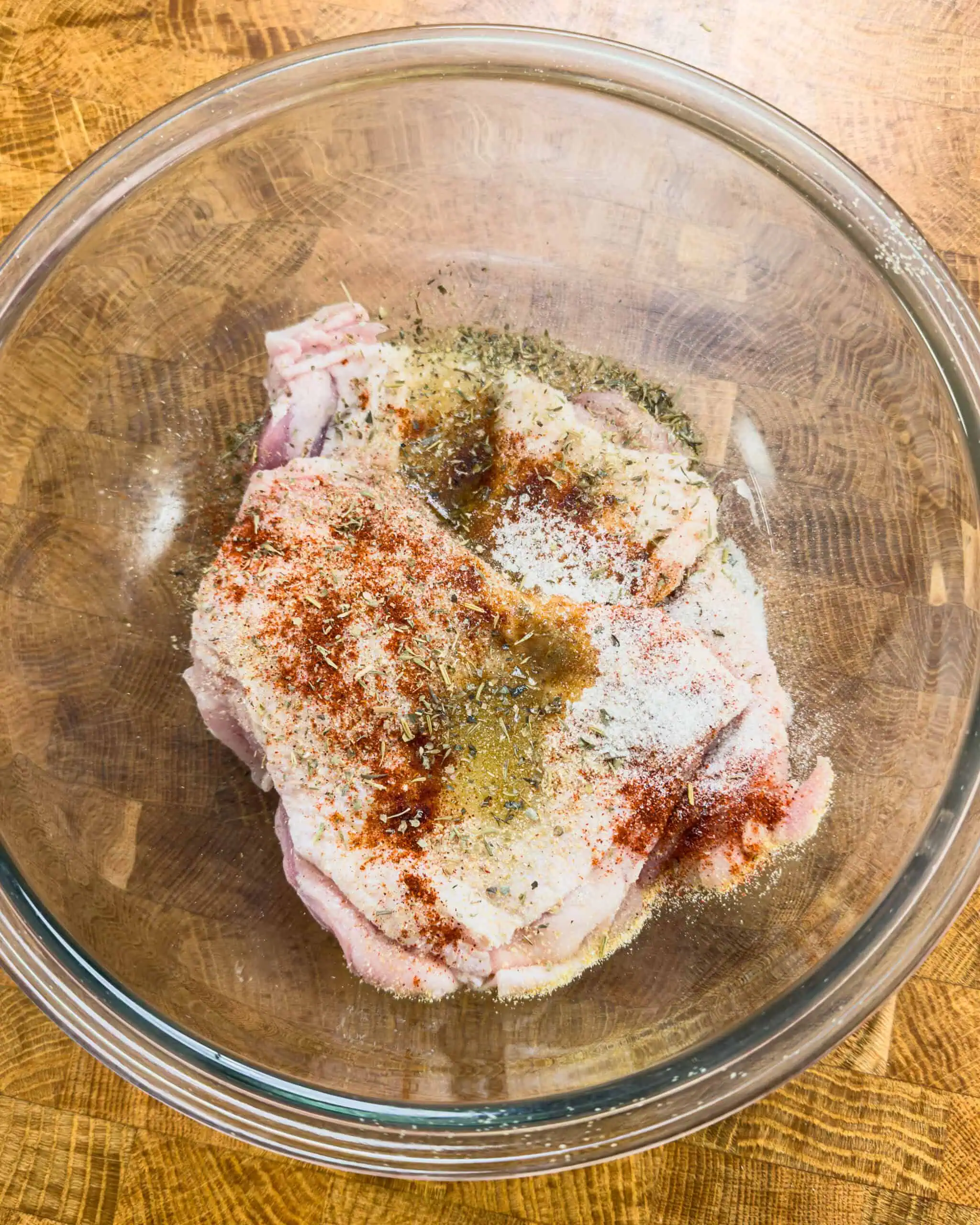 Chicken thighs seasoned with spices in a bowl - GENIUS EATS Chicken thighs seasoned with spices in a bowl