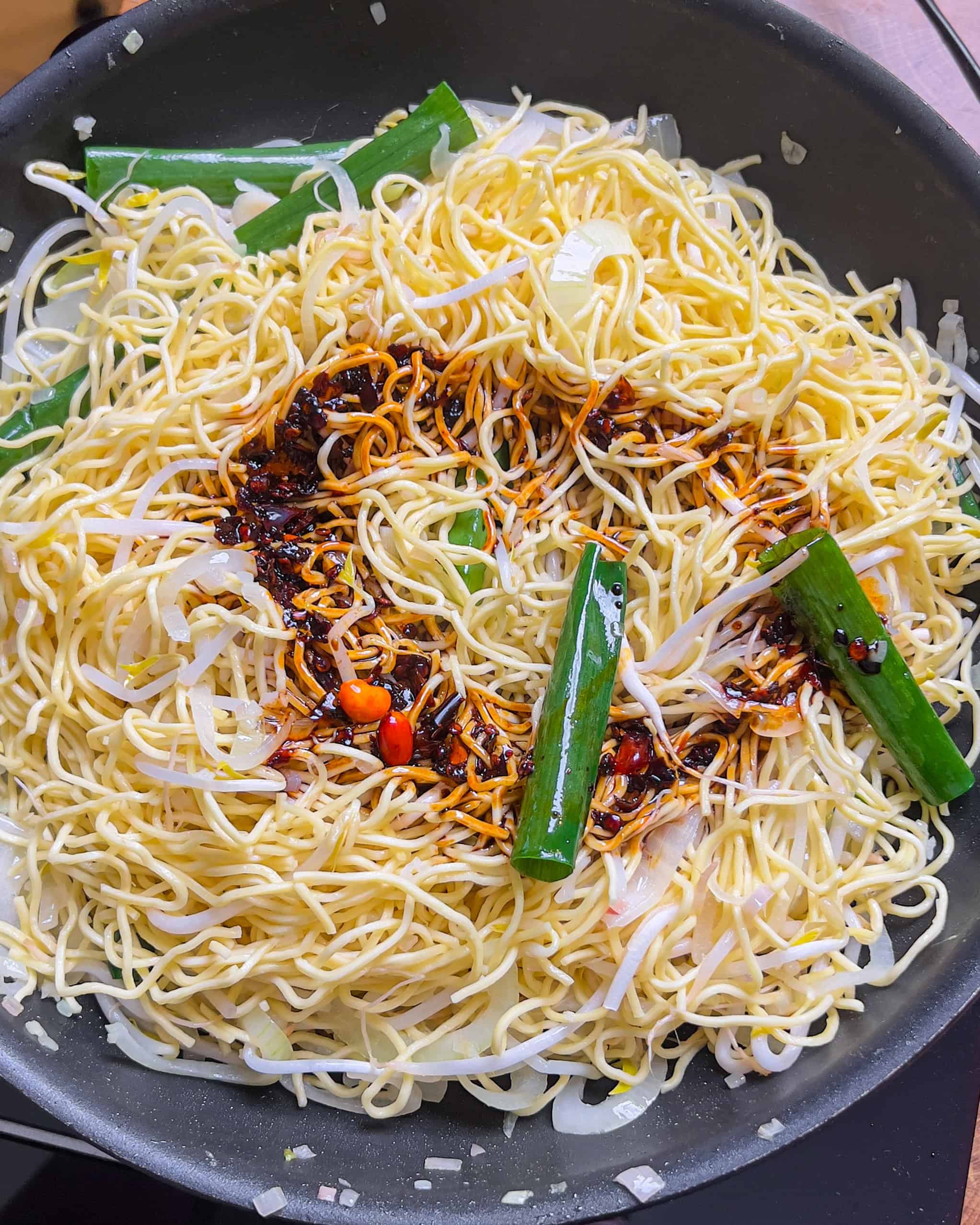 Pouring the chili oil soy sauce over the noodles for Chili Oil Soy Sauce Chow Mein - GENIUS EATS Pouring the chili oil soy sauce over the noodles for Chili Oil Soy Sauce Chow Mein