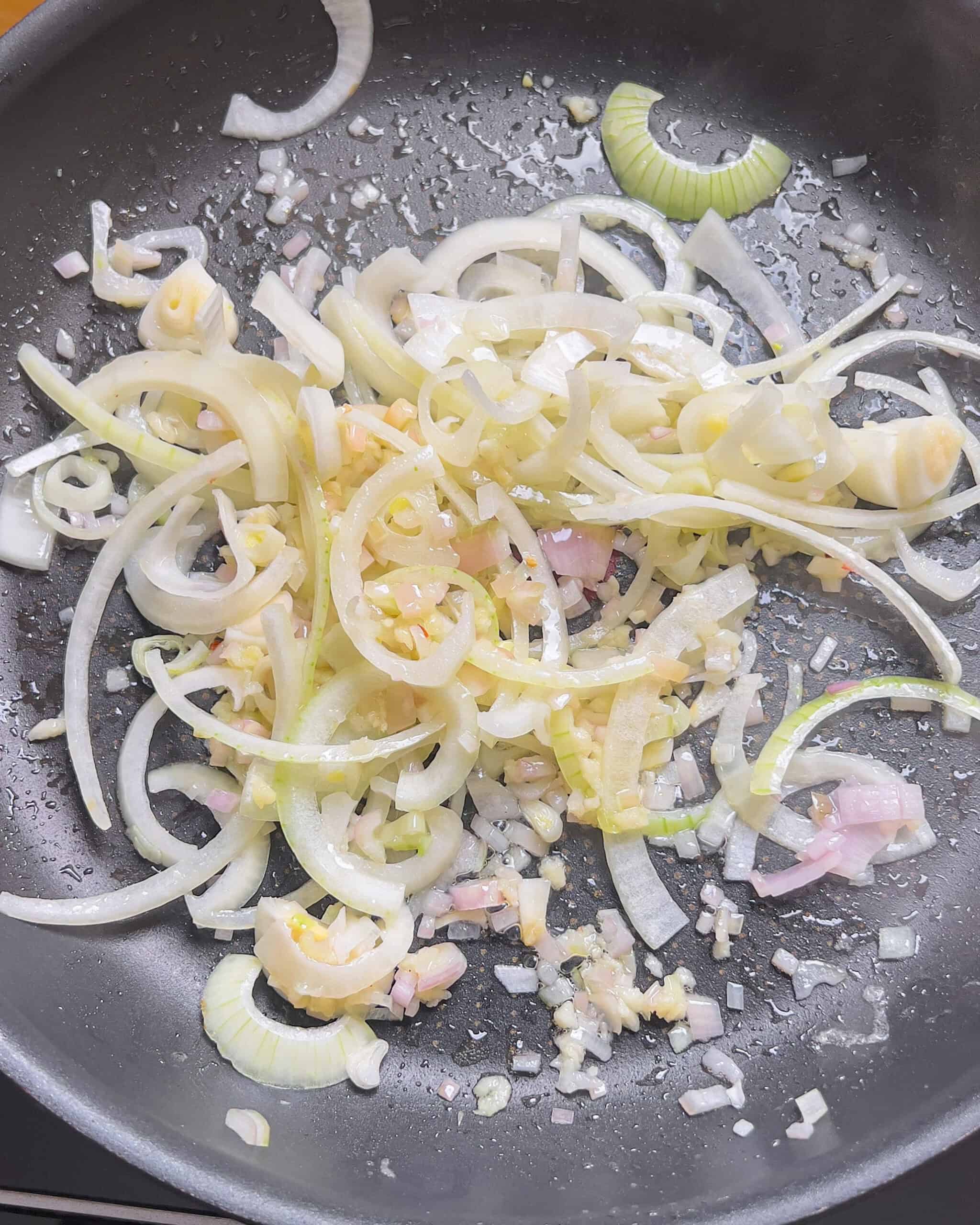 Garlic, shallot and onion sauteing in a pan for Chili Oil Soy Sauce Chow Mein - GENIUS EATS Garlic, shallot and onion sauteing in a hot pan for Chili Oil Soy Sauce Chow Mein