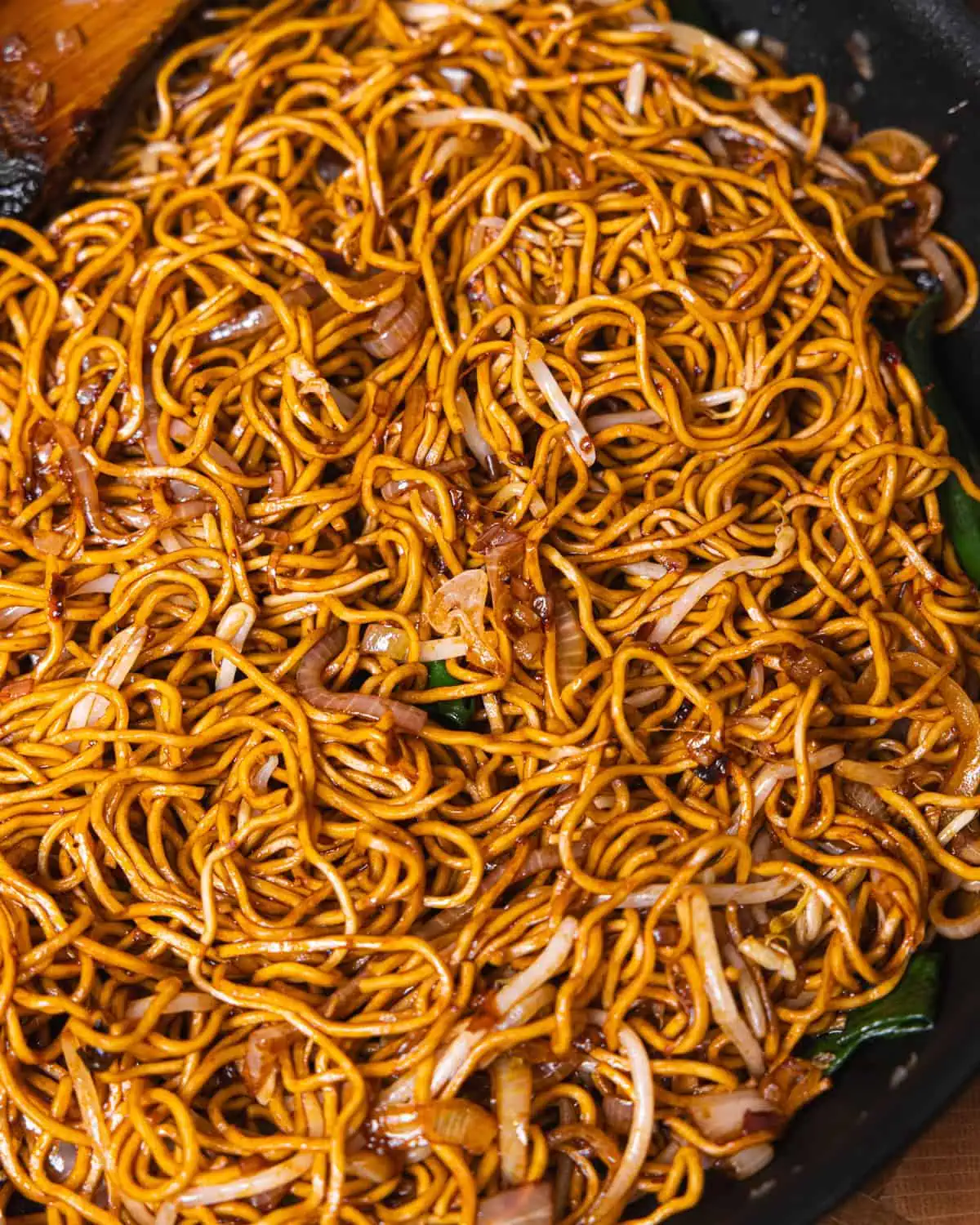 Chili Oil Soy Sauce Chow Mein noodles close up, glossy and coated in dark sauce - GENIUS EATS Chili Oil Soy Sauce Chow Mein noodles glossy and coated in dark soy and chili oil sauce
